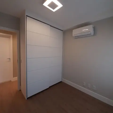 Quarto com ar-condicionado split ao lado do armário