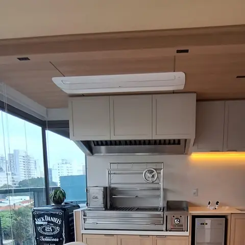 Espaço gourmet com churrasqueira e ar-condicionado cassete no forro
